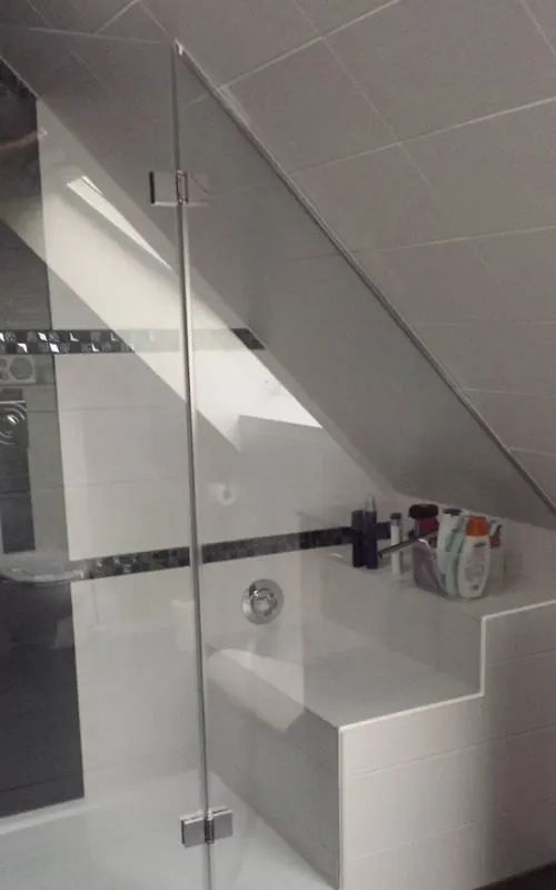 Glass shower under a sloping ceiling, the glass cut at an angle
