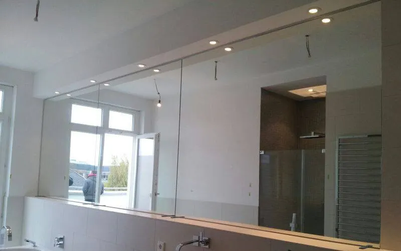 Made-to-measure wall mirror across an entire wall of a bright room